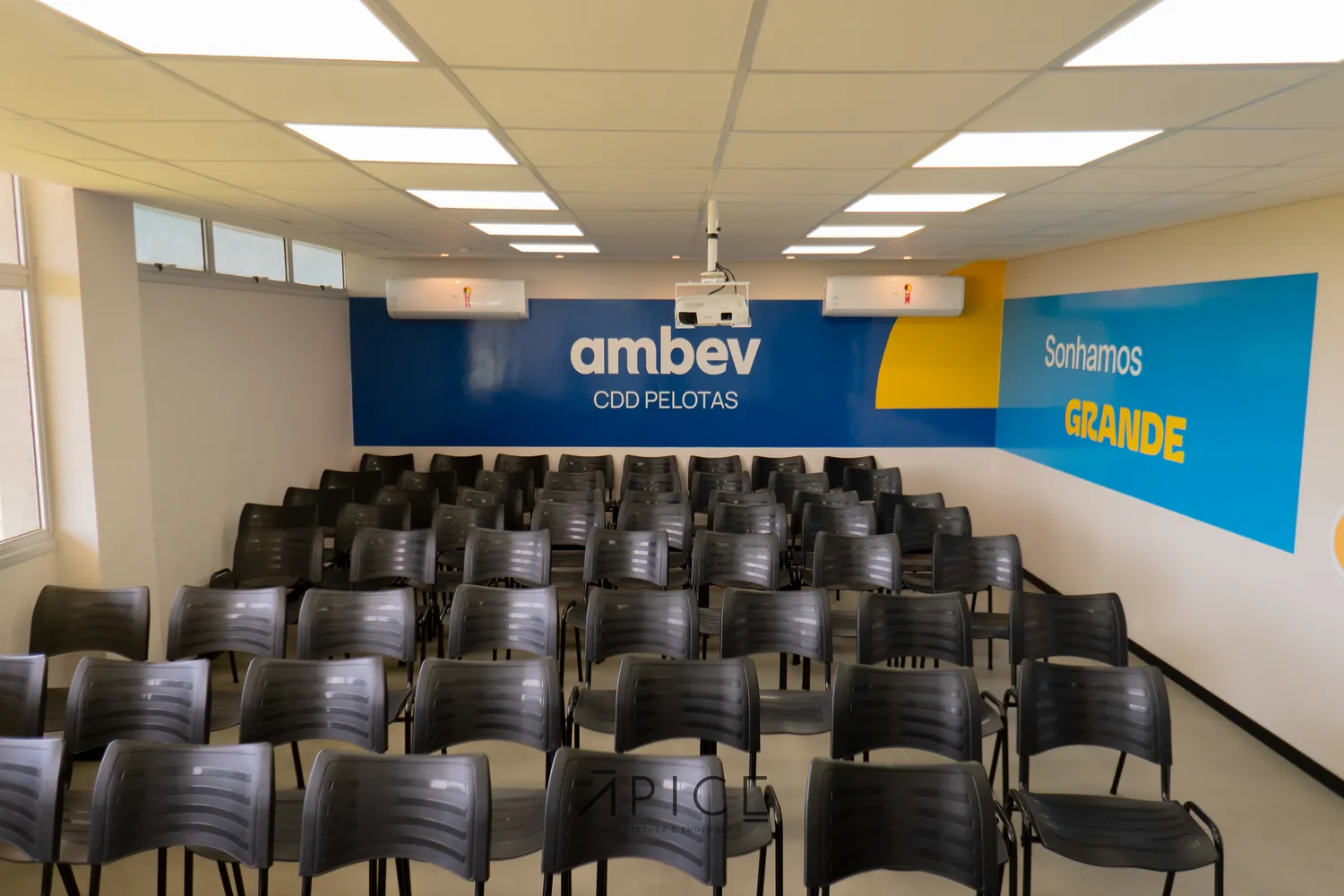 Auditório do centro de distribuição da Ambev em Pelotas, com cadeiras enfileiradas e painel institucional.