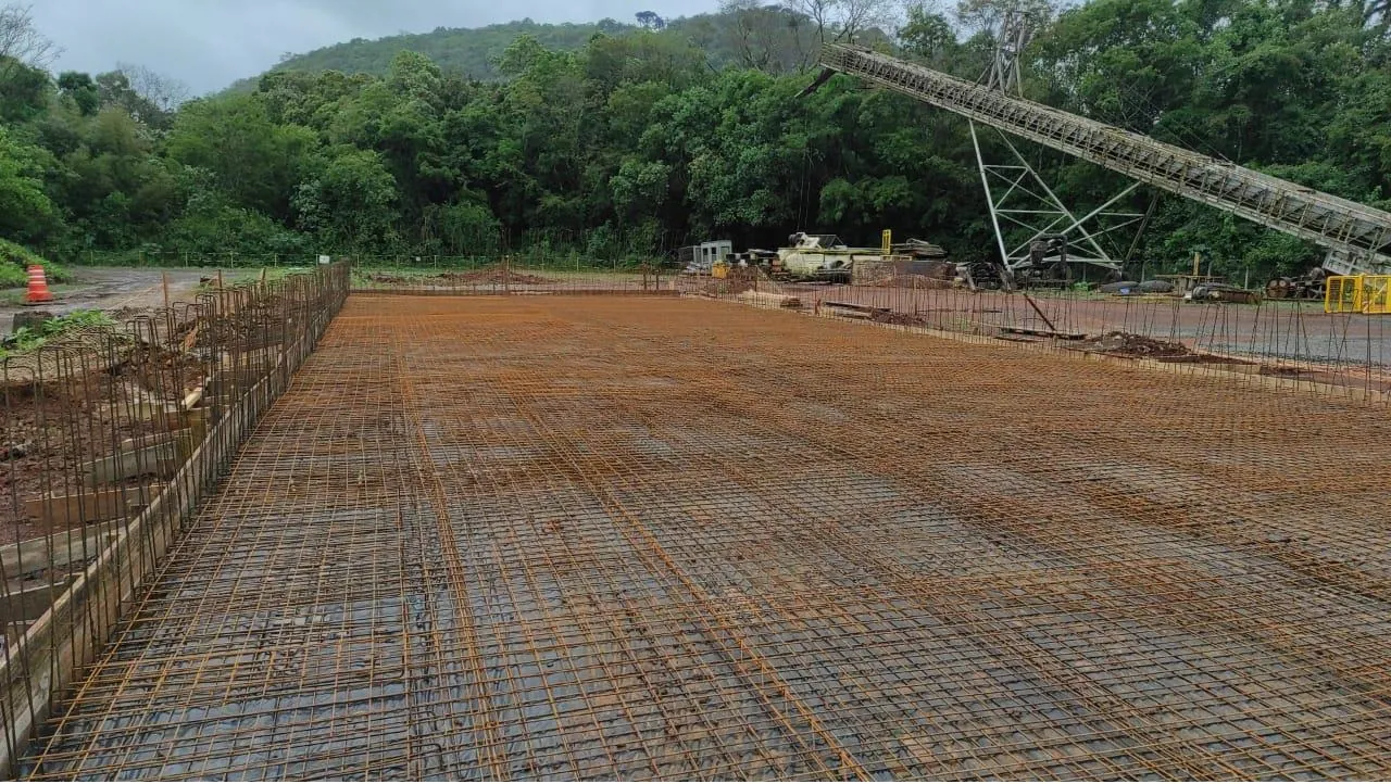 Malha de armação de aço estendida sobre a base, pronta para a concretagem do piso industrial.